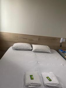 a large white bed with two pillows and a headboard at Hotel Premier in Brasilia