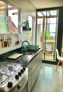 uma cozinha com um fogão e uma bancada em Bangalôs Floripa - Tiny House em Florianópolis