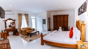 a bedroom with a large bed and a living room at Lakegala Resort in Kaluganga