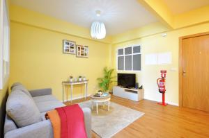 ein Wohnzimmer mit einem Sofa und einem TV in der Unterkunft RH Charming Apartment Liberdade I in Braga