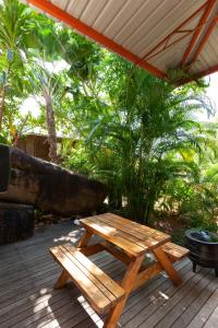 - une table de pique-nique en bois et un banc sur la terrasse dans l'établissement La Pointe Beach Huts, à Praslin