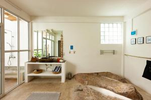 een slaapkamer met een groot bed en een spiegel bij La Pointe Beach Huts in Anse Possession