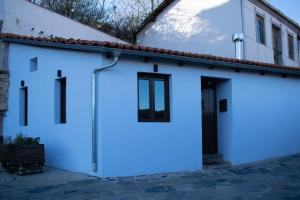 un garage bianco con una porta nera su un edificio di Casa en zona medieval a Monforte de Lemos