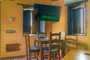 una sala da pranzo con tavolo, sedie e TV di Casa en zona medieval a Monforte de Lemos