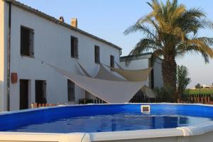 a swimming pool in front of a house with a boat sculpture at Masia Llambrich in Deltebre