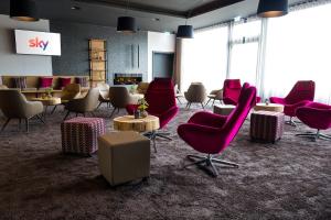 a waiting room with red chairs and tables at Rebhan's Business und Wellness Hotel in Neukenroth