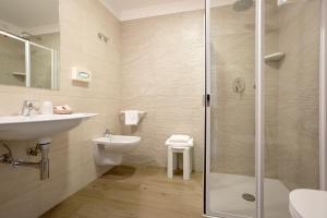 bagno con doccia, lavandino e servizi igienici di Hotel Montreal a Bibione
