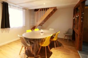 奧貝奈的住宿－Gîte Sainte Odile，一间带桌子和黄色椅子的用餐室