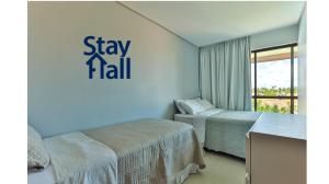 une chambre avec deux lits et un panneau indiquant rester à moitié dans l'établissement Flat com varanda+2qt no Eco Resort, à Praia dos Carneiros 41 autres photos