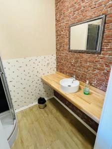 a bathroom with a sink and a brick wall at Monteur Domizil und Appartements Erfurt in Erfurt