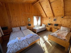 Вила Мерджан في سارنيتسا: غرفة نوم بسريرين في كابينة خشبية