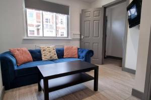 Sala de estar con sofá azul y mesa de centro en 2 BED 2 BATH & FREE PARKING - 10 MINS TO MADEJSKI STADIUM, en Theale
