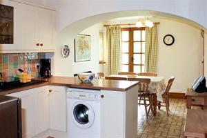 een keuken met een wasmachine en een eetkamer bij Rowan Cottage in Hawkshead