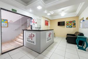 a waiting room at a clinic with a reception counter at Hotel Prainha in Vila Velha