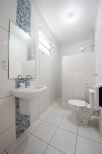 a white bathroom with a sink and a toilet at Hotel Prainha in Vila Velha +15 photos