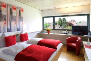 Schlafzimmer mit einem Bett mit roten Kissen und einem TV in der Unterkunft Bed & Breakfast Rotes Haus in Überlingen