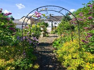a garden with a bunch of flowers and an archway at The Old Post Office, Lanchester in Lanchester