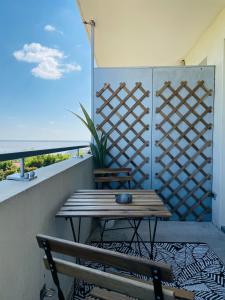 a wooden table and a bench on a balcony at Appartement T2 avec balcon, lumineux, au calme. in Blaye