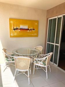 a glass table and chairs on a patio at Palm beach, Porto das dunas próximo ao Beach Park in Aquiraz