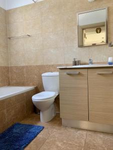 uma casa de banho com um WC, uma banheira e um lavatório. em Lazuli City Center Ap 42 em Lárnaca