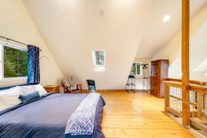 1 dormitorio con 1 cama y suelo de madera en Camano Writer's Cottage, en Indian Beach