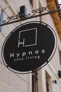 a sign for hyannis cozy living hanging on a building at Hypnos Cozy Living in Ioannina