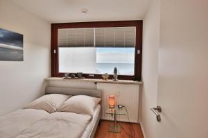 Schlafzimmer mit einem Bett und einem Fenster in der Unterkunft Hanseat am Hang 3 - 5 Hanseat App 13 Traumnest in Scharbeutz