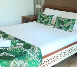 a bed with green and white sheets and pillows at Nehir Dalyan Boutique Otel in Ortaca