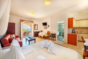 a room with a bed and a kitchen and a living room at Sunrise Beach Suites in Azolimnos Syros