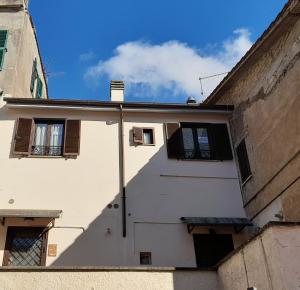 a white building with windows and a blue sky at CasaVacanze Salza nel Borgo in Sutri