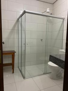 a glass shower in a bathroom with a toilet at Hotel Dallas Toríbio in Bom Jesus da Lapa