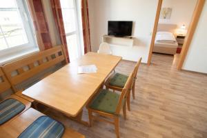 ルッツマンスブルクにあるFamily XL - Ferienwohnungenの木製のテーブルと椅子、ベッドルーム1室が備わります。