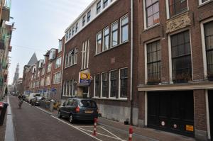 a car parked on a street next to a brick building at Modern Canal House Loft - City Center in Amsterdam