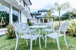 a group of white chairs and a table in the grass at Lakegala Resort in Kaluganga