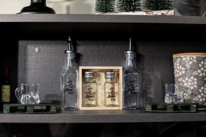 a shelf with glass bottles and glasses on it at Apartman_PidžuN in Cetinje
