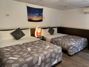 a hotel room with two beds and a lamp at Zhiben Hotspring in Wenquan