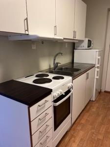 a kitchen with a white stove and a sink at Birkagatan - Visby Lägenhetshotell in Visby