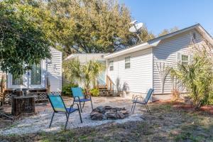 a yard with chairs and a fire pit in front of a house at Palmwood Paradise in Tybee Island