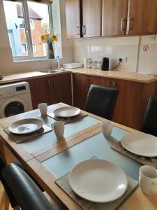 a kitchen with a table with white plates on it at Flat 1. Cleethorpes apts in Cleethorpes