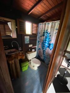 a bathroom with a toilet and a shower curtain at Dive and Green Capurgana in Capurganá