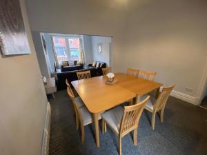 a dining room with a wooden table and chairs at Blackpool Abode - Palatine House in Blackpool