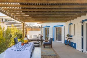 a patio with a table and chairs and a wooden pergola at Villa Nova in Comporta