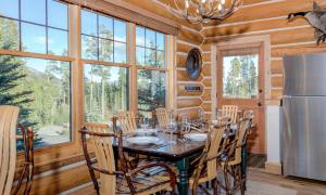 a dining room with a table and chairs and a refrigerator at Powder Ridge Cabin - 9A Red Cloud in Big Sky