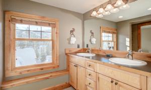 a bathroom with two sinks and a window at Powder Ridge Cabin - 9A Red Cloud in Big Sky +40 photos