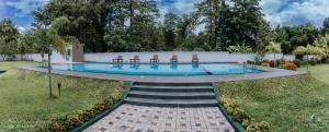 a swimming pool with chairs and stairs in a yard at Lakegala Resort in Matale