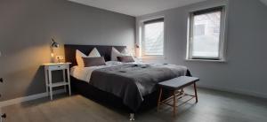 - une chambre avec un grand lit, une chaise et deux fenêtres dans l'établissement Großes schönes Ferienhaus mit Garten für 12 Personen erwartet Sie im Harz!, à Sankt-Andreasberg