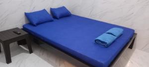 a blue bed with blue pillows next to a table at Homestay Premium 56 in Jepara