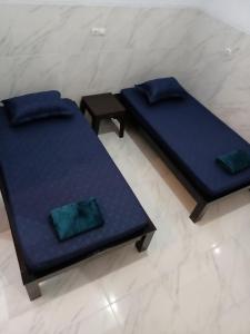 dwa łóżka z niebieskimi poduszkami na podłodze w obiekcie Homestay Premium 56 w mieście Jepara
