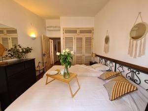 ヴィラモウラにあるAldeia do Golf - Vila I8のベッドルーム1室(花瓶のあるテーブル付)