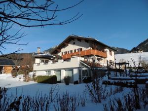 a house in the snow with snow covered grounds at Landhaus In der Au in Unterwössen